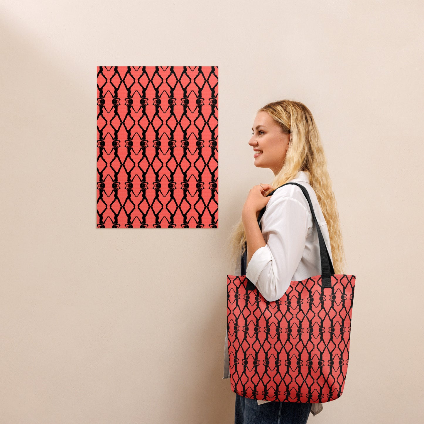 Woman holding a red and black patterned tote bag next to a matching wall art piece.