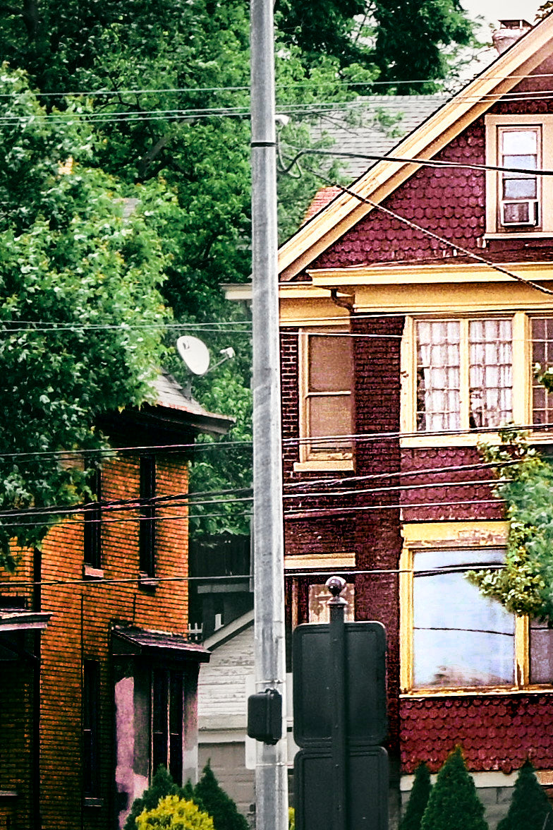 Image of a brick house on a busy street. Image taken by Jonnise Macomson