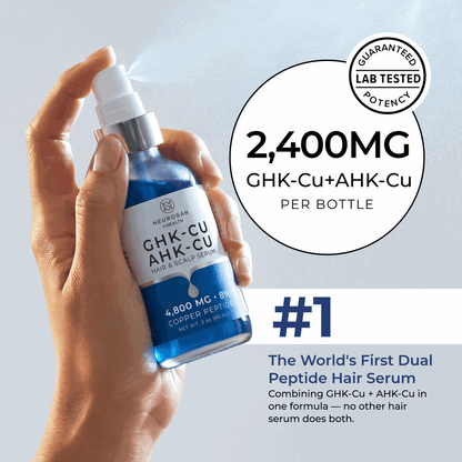 Hand holding a blue hair serum bottle with text about its ingredients and benefits on a light gray background.