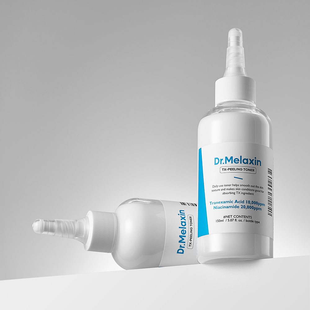 Two bottles of Dr. Melanax TX-Peeling Toner on a gray background