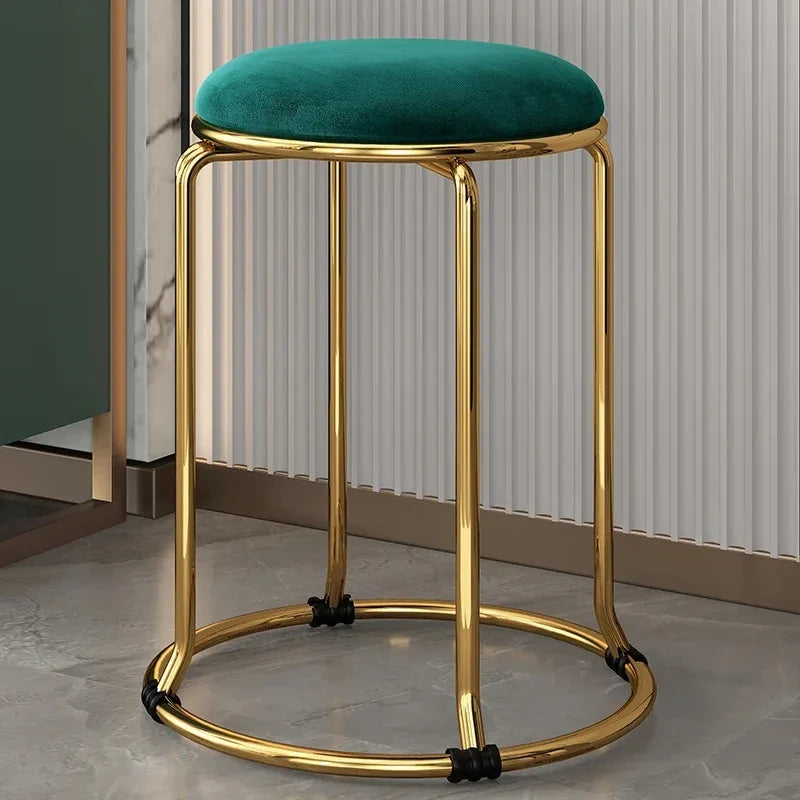 Green velvet bar stool with gold metal frame on a neutral background