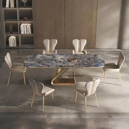 Dining table with marble top and modern chairs in a room with wooden floor and shelves.