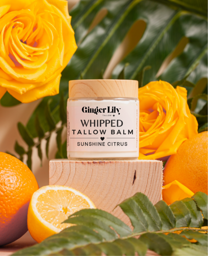 Ginger Lily whipped tallow balm jar with yellow roses and oranges on a wooden block