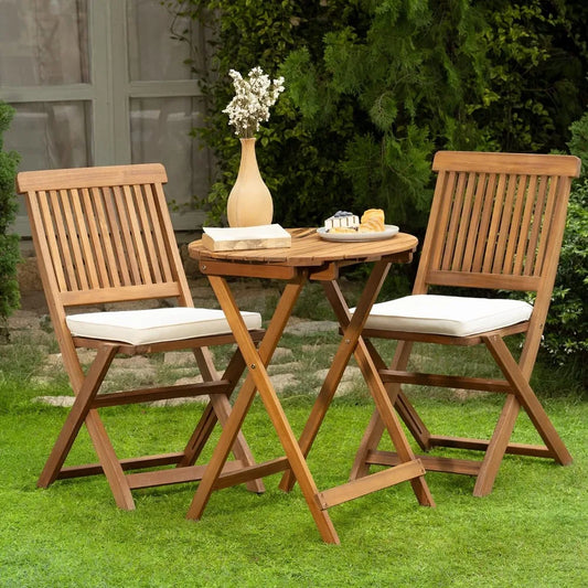 Wooden outdoor table with two chairs on a grassy area