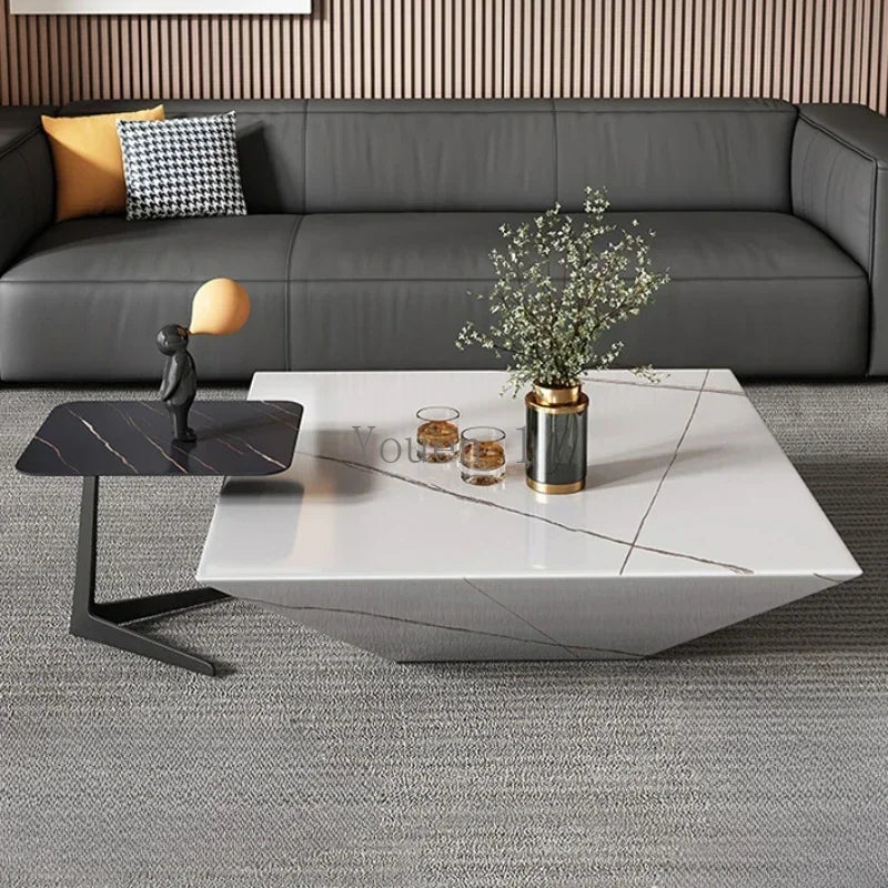 Modern living room with a gray sectional sofa, marble coffee table, and decorative items.