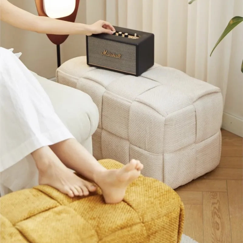 Person using a Marshall foot massager on a cushioned ottoman.