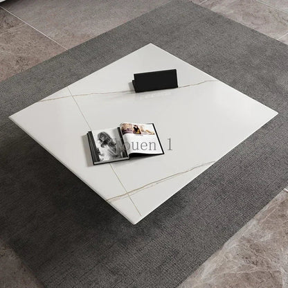 White square rug with a black rectangular object and an open book on a gray tiled floor.