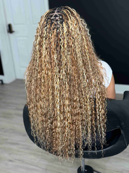 Person with long, wavy hair sitting in a chair indoors.