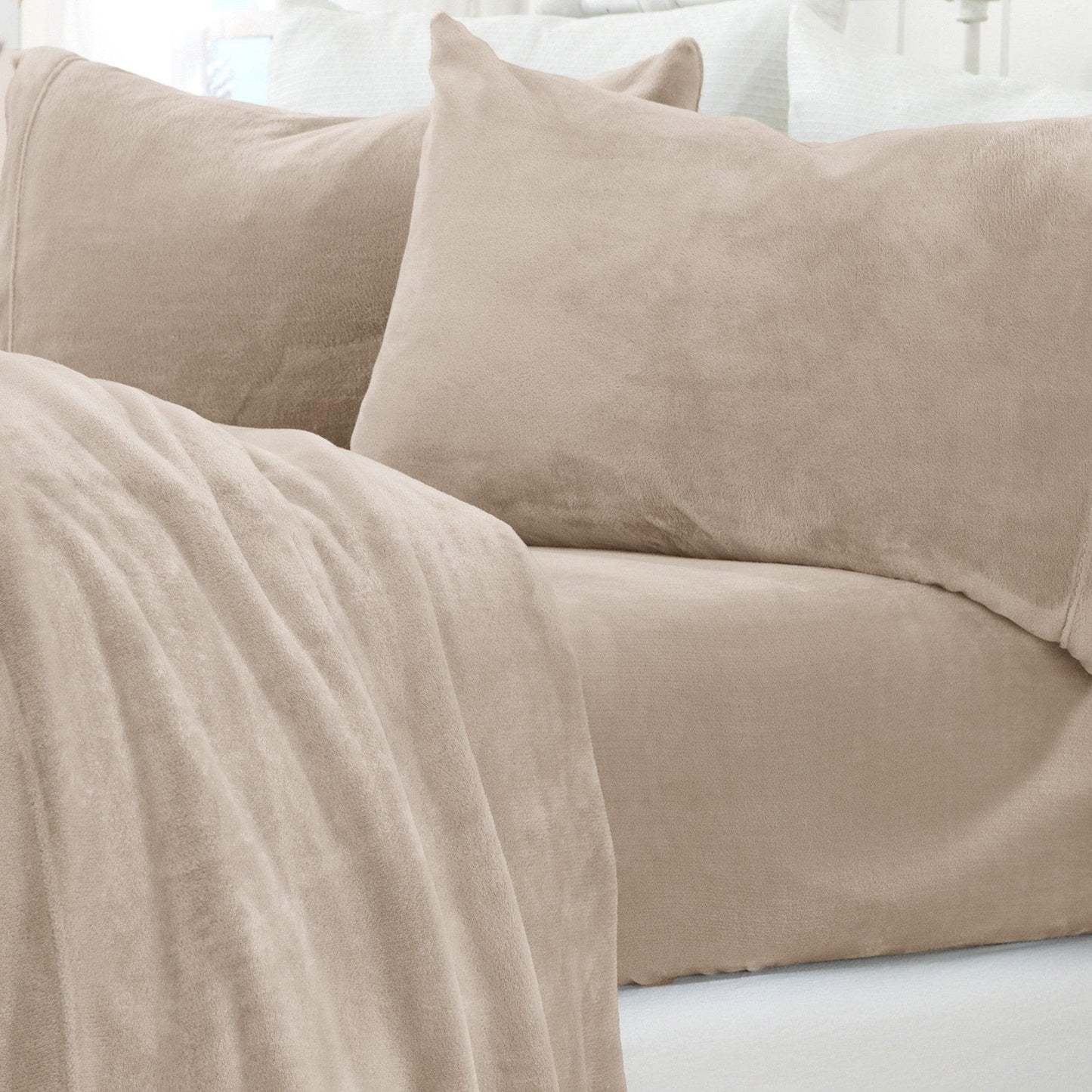 Beige sofa with a blanket and pillows in a neutral setting