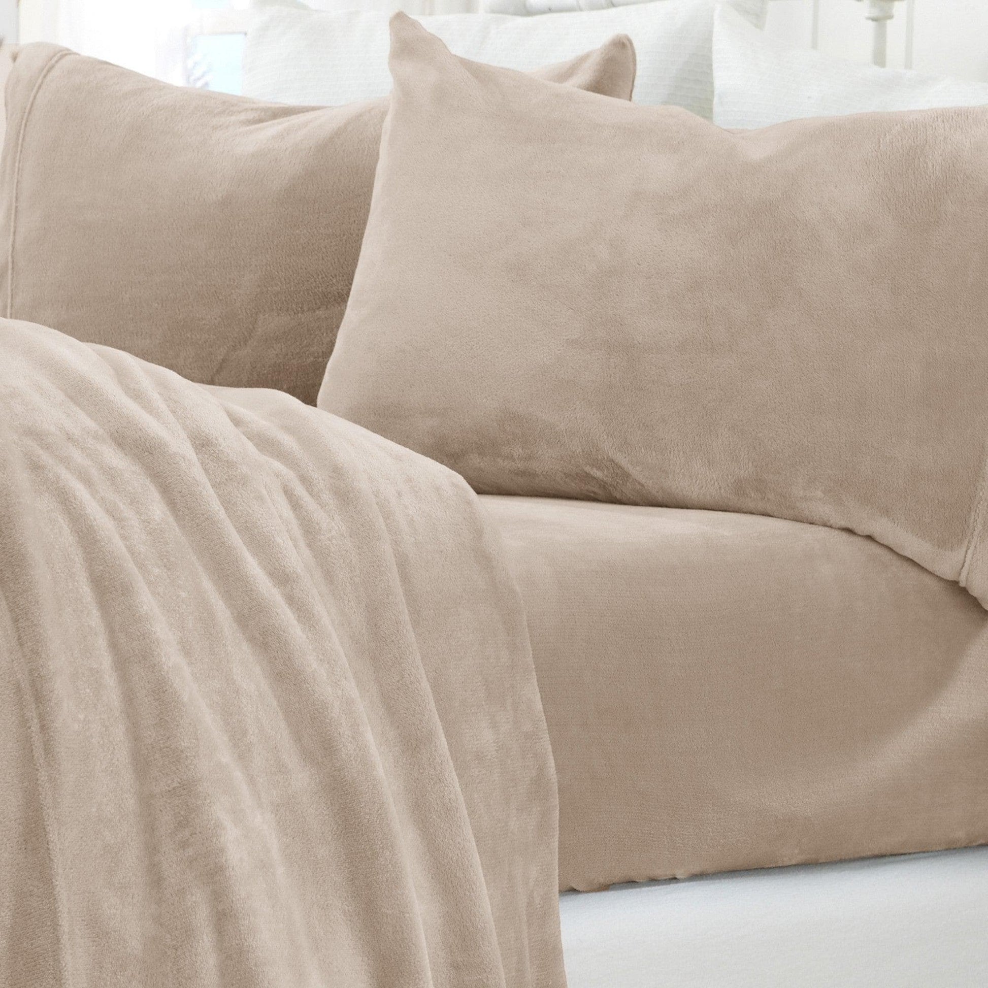 Beige sofa with a blanket and pillows in a neutral setting