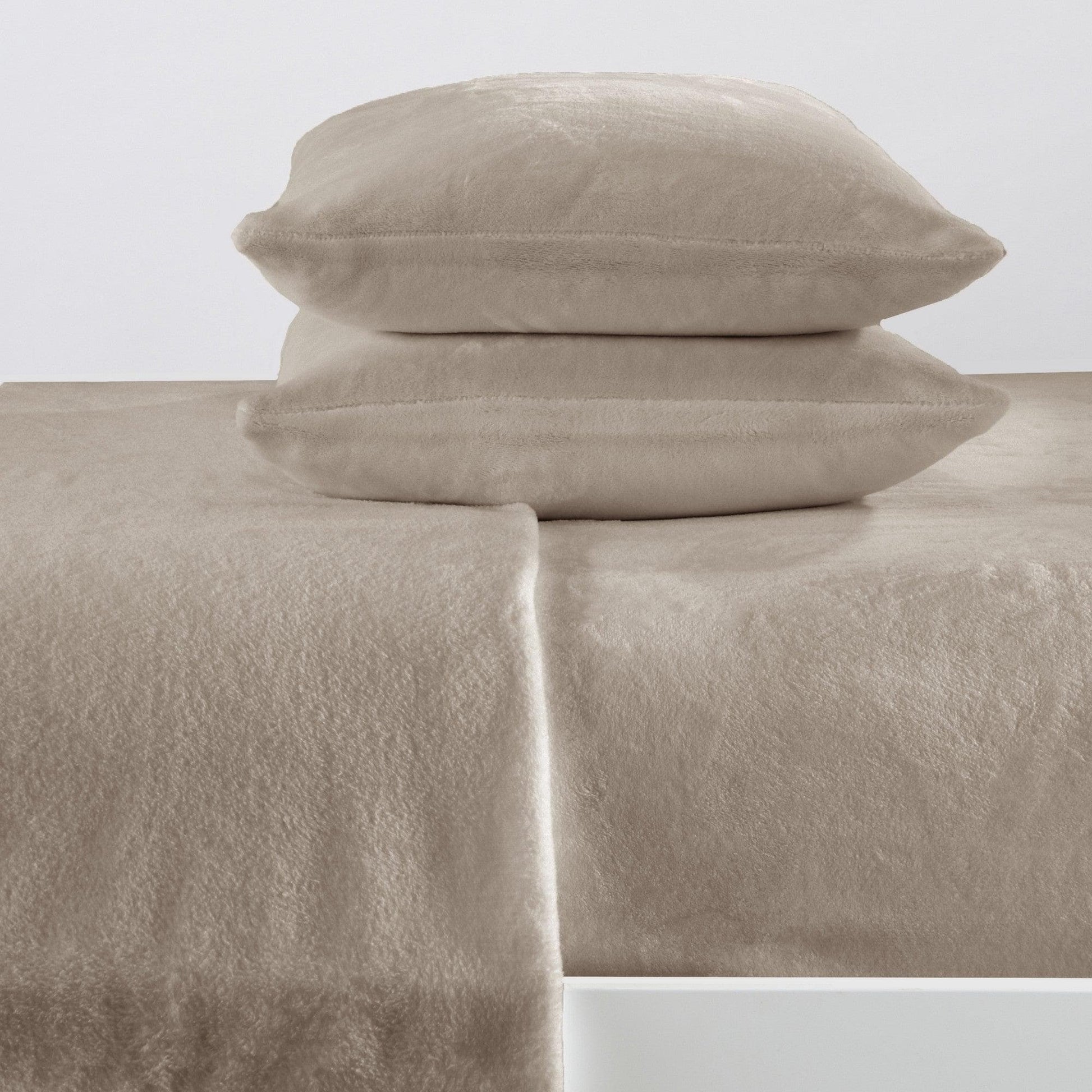 Beige bed sheets and pillows on a white background