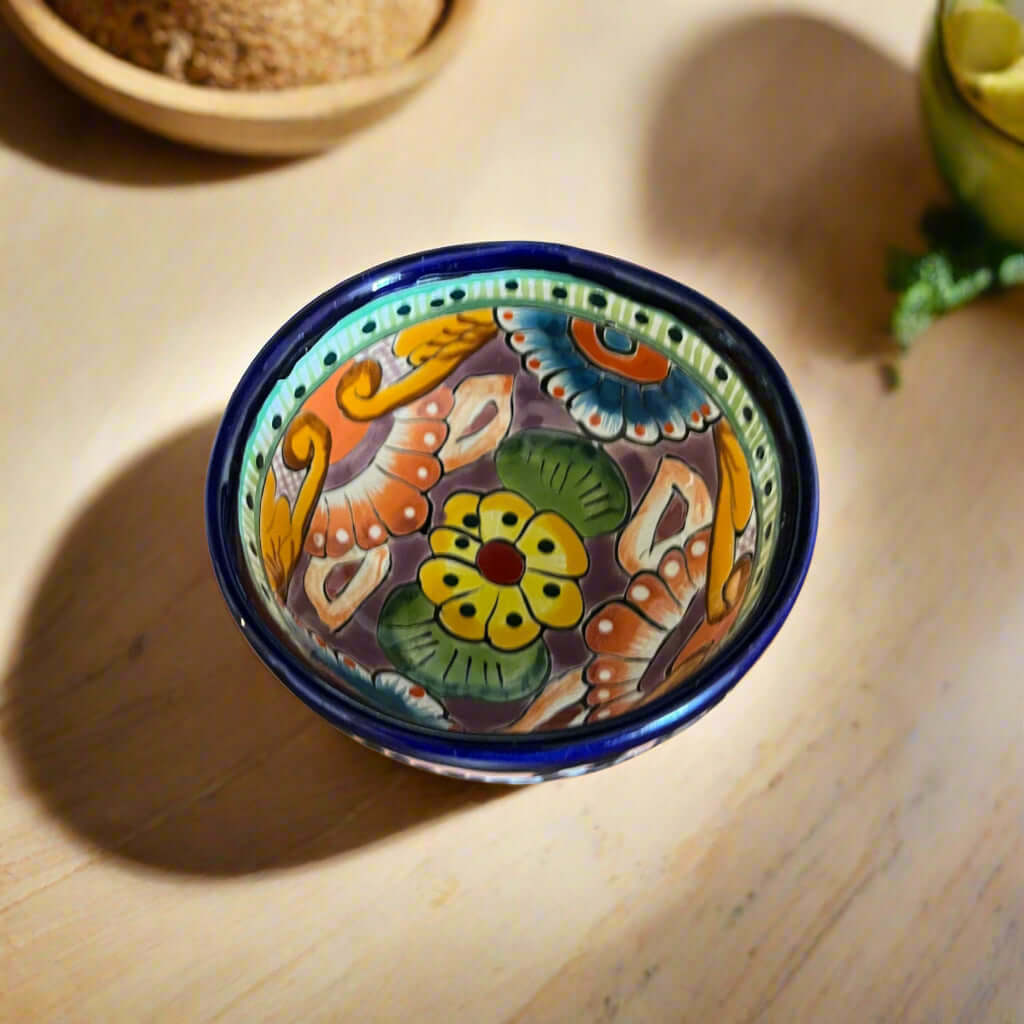 Decorative ceramic bowl with colorful patterns on a wooden surface