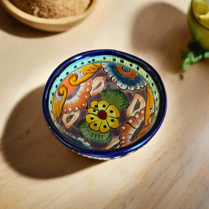 Decorative ceramic bowl with colorful patterns on a wooden surface