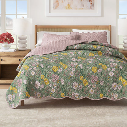 Floral quilt on a bed in a bedroom setting with a lamp and decor.