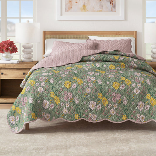 Floral quilt on a bed in a bedroom setting with a lamp and decor.