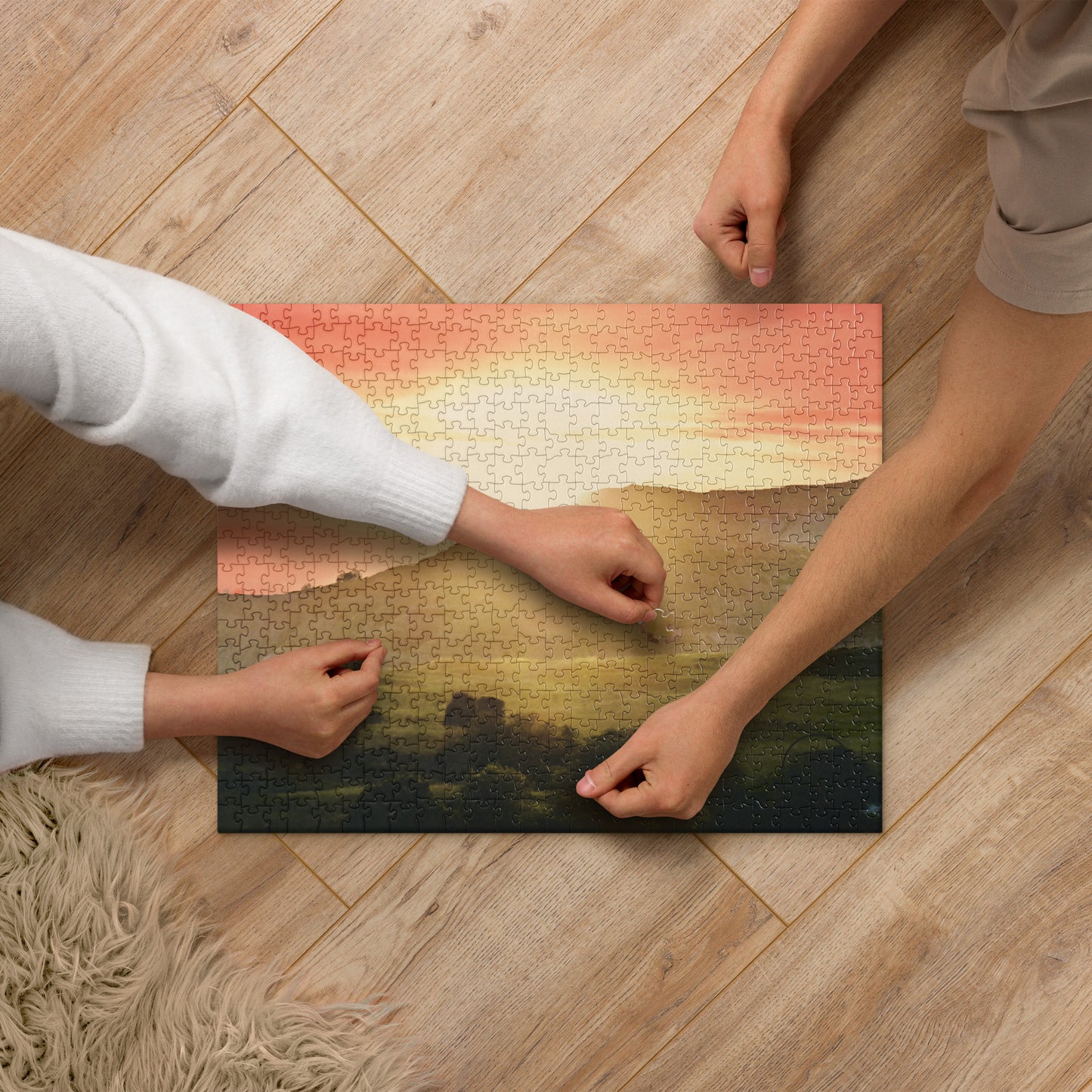 2 individuals completing a jigsaw puzzle with a beautiful sunset landscape