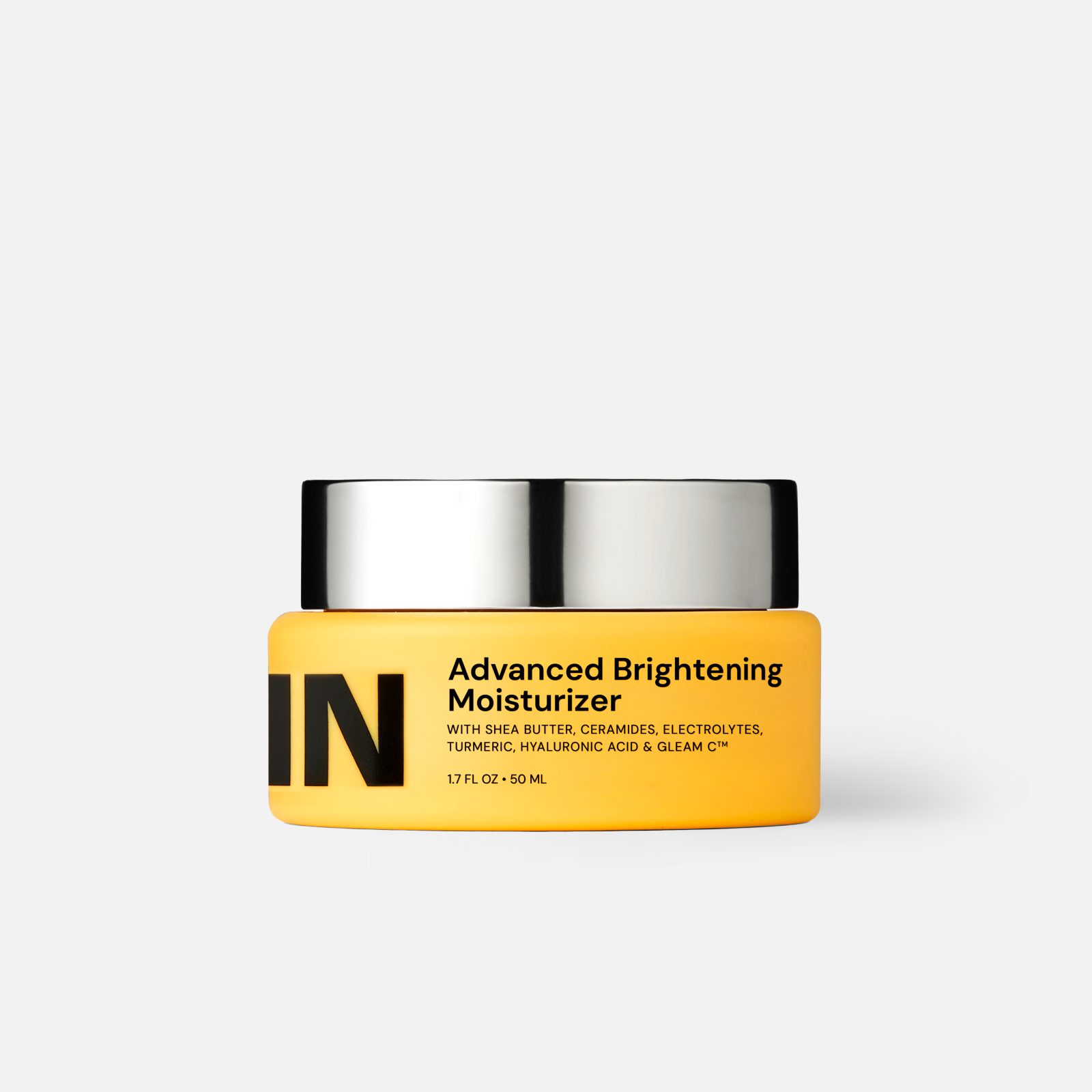 Yellow jar of 'IN' Advanced Brightening Moisturizer on a white background