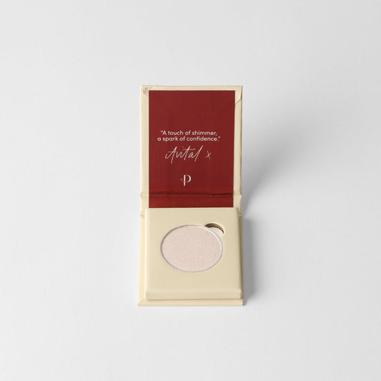 Makeup compact with a red lid and beige case on a light gray background
