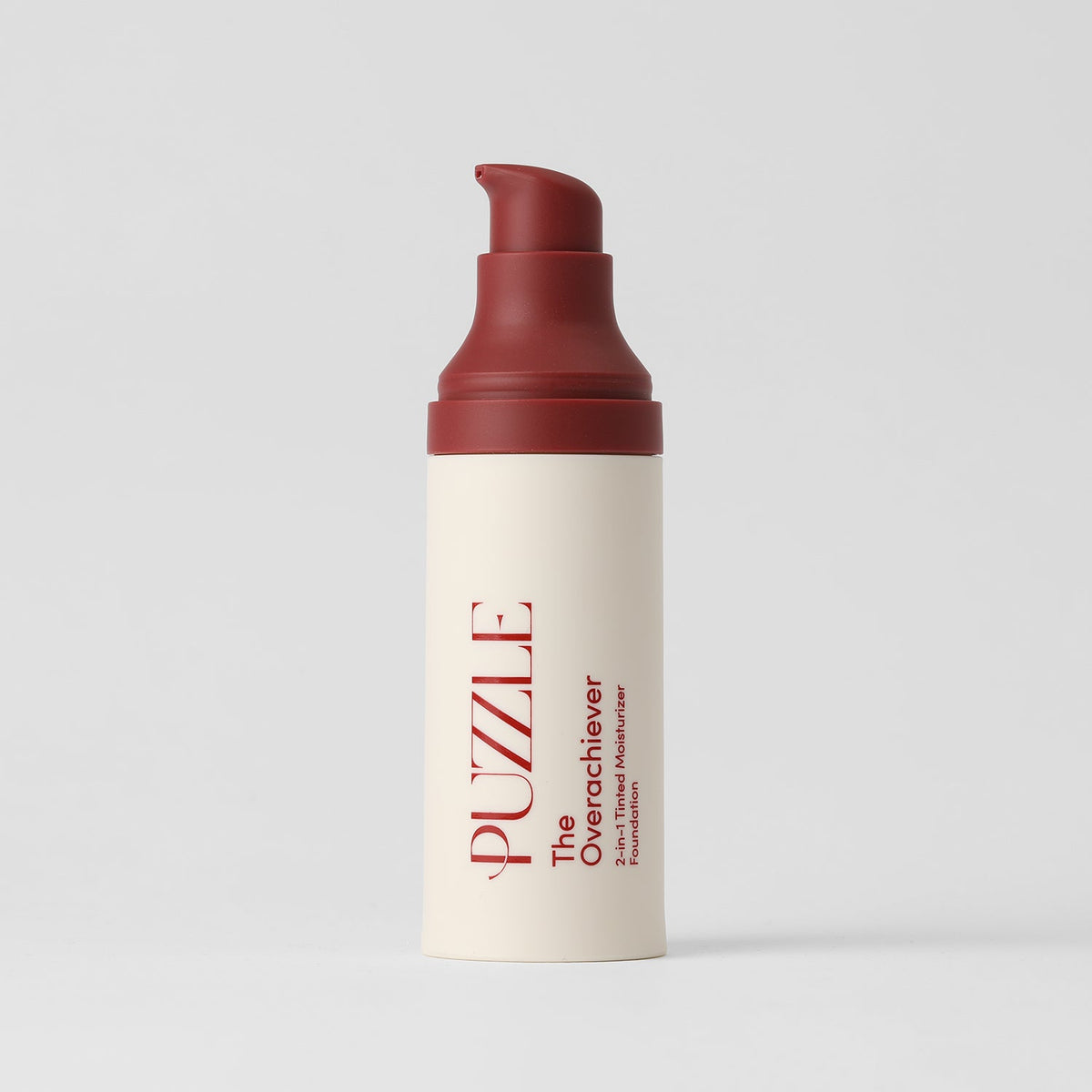 Skincare bottle with red cap and beige body on a light gray background