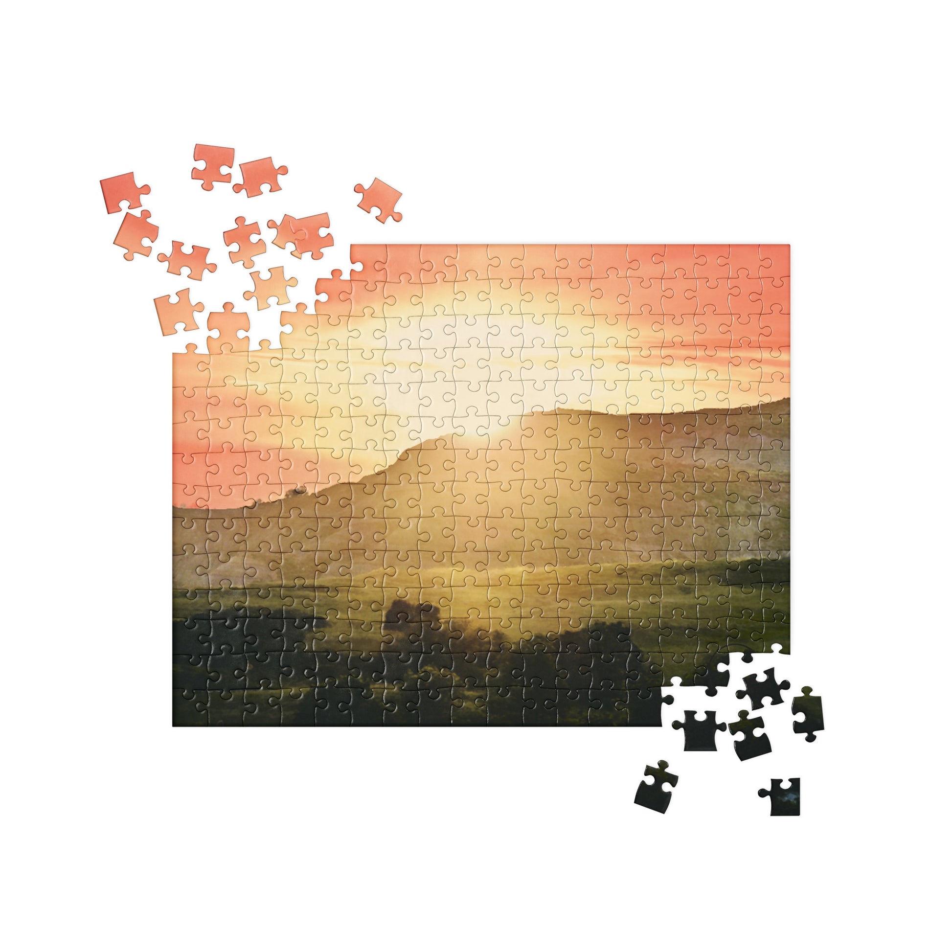 Partial puzzle of a sunset over a field with missing pieces.