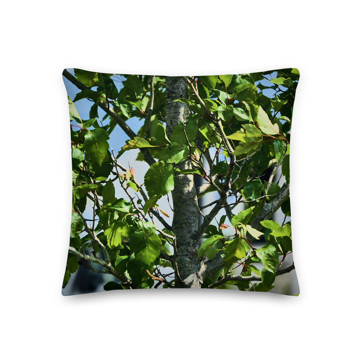 Decorative pillow with a tree and leaves design on a white background