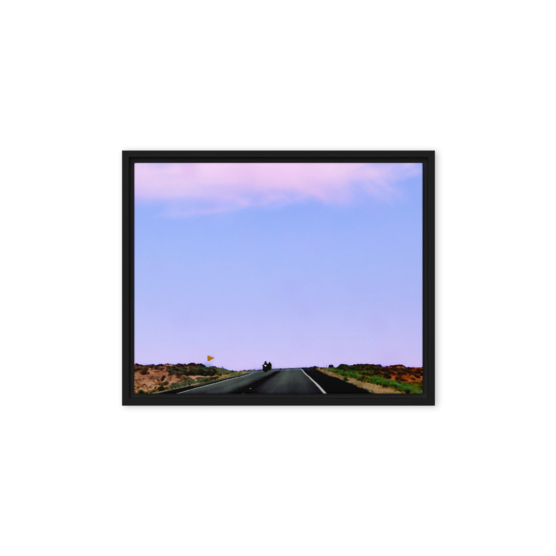 Motorcycles approaching the view on a scenic shot out west with a lavender colored sky.