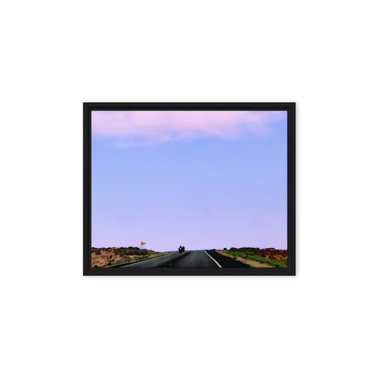 Motorcycles approaching the view on a scenic shot out west with a lavender colored sky.