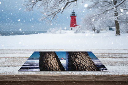 Your Suggested Brand Jigsaw puzzle with a lighthouse scene framed by tree trunks.