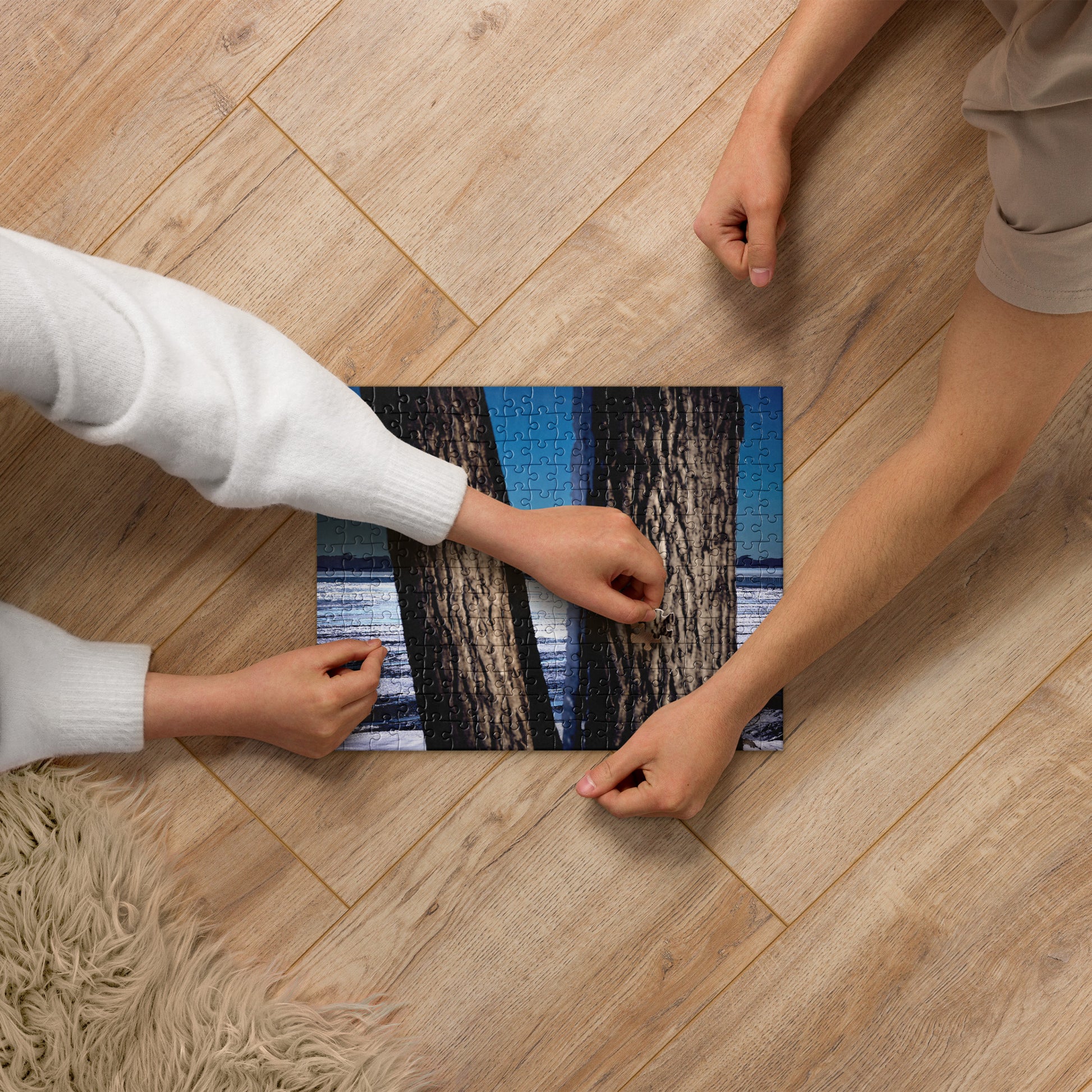 Two people working on a Your Suggested Brand jigsaw puzzle on a wooden floor